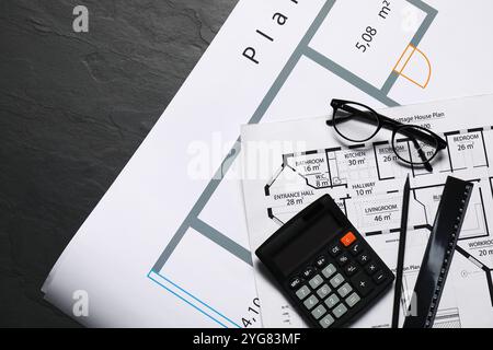 Différents dessins architecturaux, verres, calculatrice et règle sur table texturée grise, pose à plat Banque D'Images
