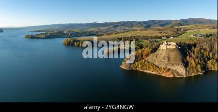 Pologne. Large panorama de drone aérien du lac artificiel Czorsztyn avec golfes et péninsules, ruines du château médiéval Czorsztyn et chaîne de montagnes Gorce Banque D'Images