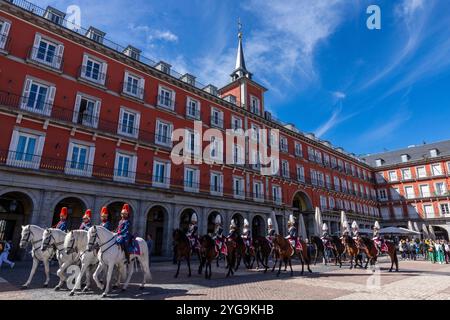 Madrid, Espagne - 08 avril 2024 : militaires hommes et femmes en uniforme de cérémonie et montés sur des chevaux, participent à un défilé, surveillé par des touristes sur un Banque D'Images