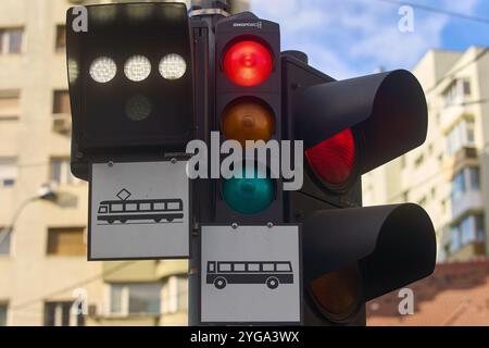 Bucarest, Roumanie - 04 novembre 2024 : feux de circulation pour voitures, tramways et bus avec des feux rouges, jaunes et verts vifs. Banque D'Images