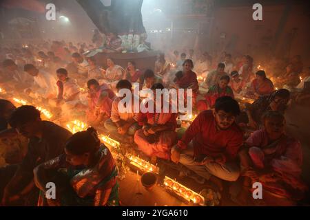 Narayanganj. 7 novembre 2024. Les dévots s'assoient pour la prière avec de l'encens brûlants et des lampes à huile légère pendant le Rakher Upobash, un festival de jeûne religieux, dans un temple à Narayanganj, Bangladesh, le 5 novembre 2024. Crédit : Xinhua/Alamy Live News Banque D'Images