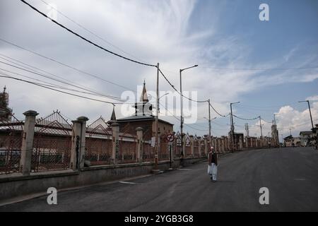 Un homme marche dans la rue déserte à l'extérieur de la grande mosquée du Cachemire pendant le confinement du COVID-19 le dernier vendredi du Ramadan à Srinagar, au Cachemire administré par l'Inde, le 7 mai 2021. Des milliers de personnes assistent aux prières les jours normaux chaque année en raison du covid-19. Toutes les mosquées principales ont été fermées. Banque D'Images