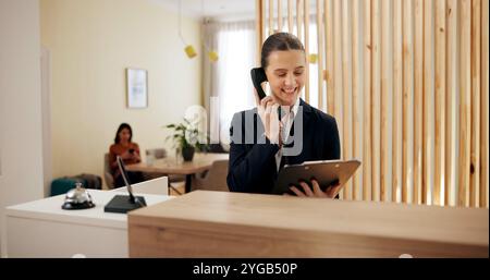 Presse-papiers, femme et réceptionniste dans l'hôtel avec téléphone, réservation horaire et check-list sur le comptoir. Service d'assistance, accueil et concierge avec Banque D'Images