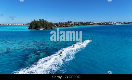 Un tir dynamique par drone capture des jet-skis de course qui traversent les superbes eaux des Bermudes, créant des éclaboussures et des sentiers dans la mer Banque D'Images