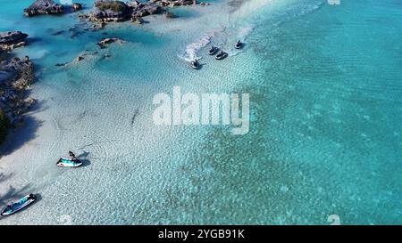 Un tir dynamique par drone capture des jet-skis de course qui traversent les superbes eaux des Bermudes, créant des éclaboussures et des sentiers dans la mer Banque D'Images