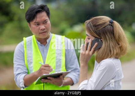 Femmes problème de voiture accident parler téléphone appeler pour l'aide agent d'assurance agent agent d'évaluation des dommages au bord de la route. Banque D'Images