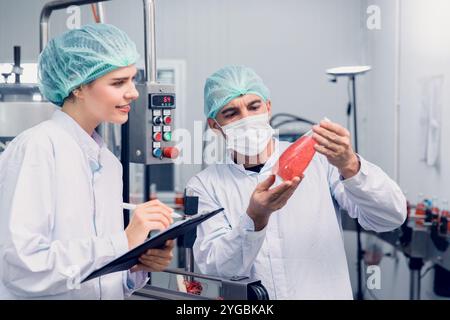 Les inspecteurs du contrôle de la qualité et de la sécurité alimentaire testent et vérifient les normes de contamination des produits dans la chaîne de production de l'usine d'aliments et de boissons avec des soins d'hygiène. Banque D'Images