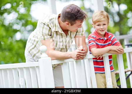 Maison, garçon et sourire avec le père sur le balcon pour le soutien, le lien et les soins au Canada. Les gens, les parents et heureux avec l'enfant comme la famille sur la rupture avec l'amour Banque D'Images