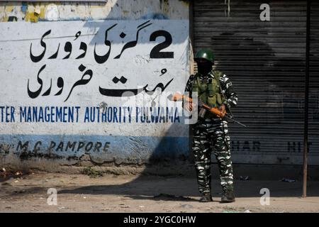 Un soldat paramilitaire indien se tient en alerte dans une rue déserte lors d'une fusillade entre les forces indiennes et des militants dans la zone de Pampore, dans le district de Pulwama, au sud de Srinagar, au Cachemire sous administration indienne, le 16 octobre 2021. Deux militants ont été tués lors de la fusillade, mais quatre maisons d'habitation ont été endommagées, dont l'une a été soufflée par les forces indiennes. Banque D'Images