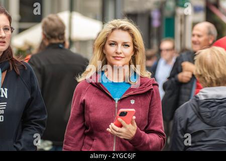 Portrait de rue de la femme de Dublin. Une jeune femme blonde dans une veste rouge marche à Dublin Street. Dublin, Irlande. Banque D'Images