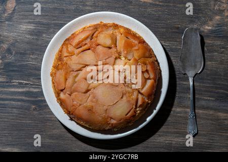 Tarte traditionnelle aux fruits tranchés avec poires et miel dans l'assiette, gros plan, vue de dessus. Tarte tatin, type de tarte aux fruits française à l'envers dans laquelle le fruit i Banque D'Images