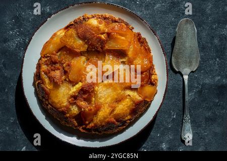 Tarte traditionnelle aux fruits tranchés avec pomme et miel dans l'assiette, gros plan, vue de dessus. Tarte tatin, type de tarte aux fruits française à l'envers dans laquelle le fruit i Banque D'Images