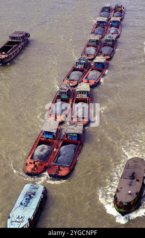 Chine, Shanghai, un bateau tire 12 barges avec du gravier sur la rivière Huangpu. Banque D'Images