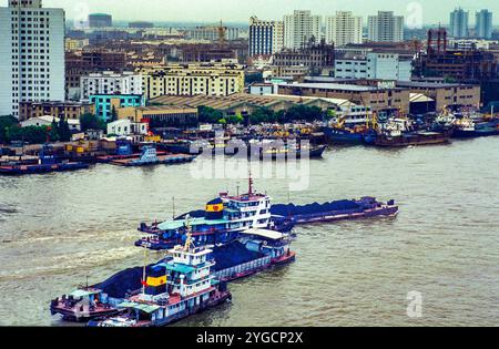La Chine, Shanghai, les bateaux pousseurs ou remorqueurs poussent des barges avec du charbon sur la rivière Huangpu. Banque D'Images