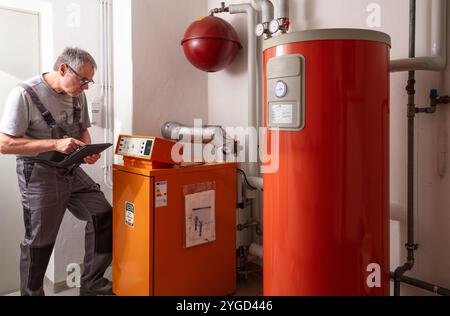 l'installateur vérifie un ancien chauffage au gaz Banque D'Images