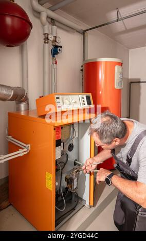 l'installateur vérifie un ancien chauffage au gaz Banque D'Images