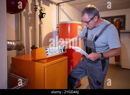 l'installateur vérifie un ancien chauffage au gaz Banque D'Images