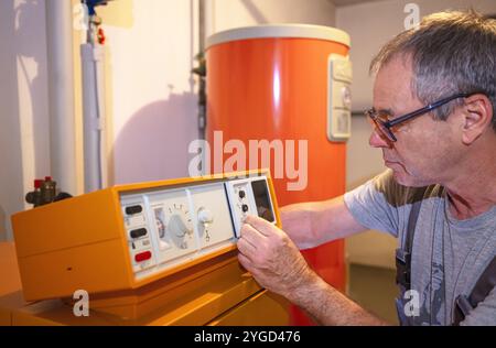 l'installateur vérifie un ancien chauffage au gaz Banque D'Images