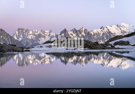 Ambiance du soir avec ciel rose du soir, paysage de montagne au coucher du soleil, reflet de l'eau dans le Lac Blanc, sommets des grandes Jorasses et Mont Blanc du Banque D'Images