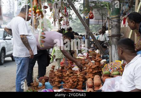 Les gens achètent des lampes à huile Diya et d'autres objets décoratifs sur un marché à la veille de Diwali, la fête hindoue des lumières, à Guwahati, en Inde, le 30 octobre Banque D'Images