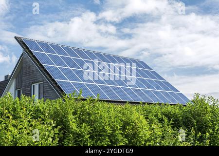 Maison avec panneaux solaires sur le toit par une journée ensoleillée Banque D'Images