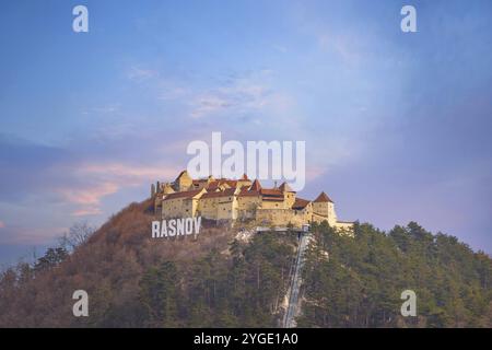 Rasnov, Roumanie, 25 mars 2015 : citadelle médiévale sur la colline, panneau avec le nom de la ville et église à Rasnov, Transylvanie, Roumanie, Europe Banque D'Images