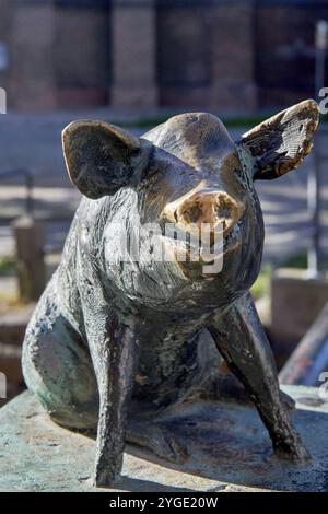 Sculpture en bronze d'un sanglier souriant en position assise, pont de cochon avec le groupe de figures de quatre cochons sur les poteaux de garde-corps, créé en 1989 Banque D'Images