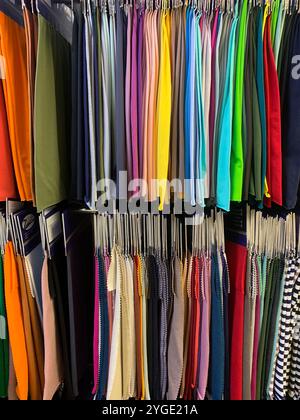 Une collection vibrante d'échantillons de tissus disposés dans un magasin de textile. Cette image présente une variété de couleurs et de textures, parfaites pour la mode et des Banque D'Images