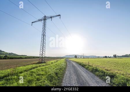 Route de terre à côté des lignes électriques dans le paysage rural Banque D'Images