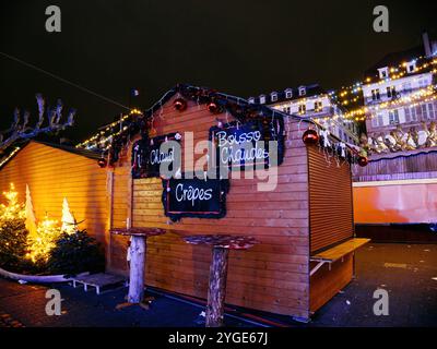 Strasbourg, France - 23 déc. 2024 : stalle en crêpe décorée de lumières et d'ornements festifs se ferme après les heures d'ouverture au marché de Noël de Strasbourg, place Broglie Banque D'Images