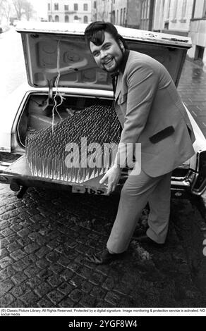 Un fakir avec son tapis de clous. Le fakir suédois Mr. Swing, de son vrai nom Kjell Swing (1942-1988). Photographié à Malmö Suède transportant son lit de pointes dans le coffre de sa voiture, une Pontiac Grand prix 1964. 1969 Banque D'Images