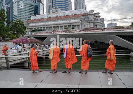 20.10.2024, Singapur, Republik Singapur, Asien - Eine Gruppe buddhistischer Moenche in ihren traditionellen orangenen Roben besucht den Merlion Park am Ufer des Singapore River in Marina Bay mit dem Fullerton Hotel und dem CBD Geschaeftszentrum im Hintergrund. *** 20 10 2024, Singapour, République de Singapour, Asie Un groupe de moines bouddhistes dans leur robe orange traditionnelle visite Merlion Park sur les rives de la rivière Singapour à Marina Bay avec l'Hôtel Fullerton et le centre d'affaires CBD en arrière-plan Banque D'Images