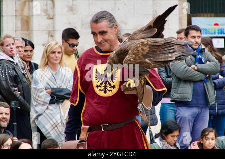 Un manipulateur d'oiseaux en costume médiéval avec un aigle doré Aquila chrysaetos lors d'une exposition d'oiseaux de proie à El CID fiestas Burgos Espagne Banque D'Images