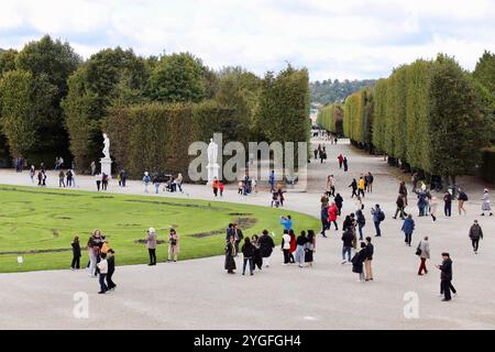 Vienne, Autriche - 6 octobre 2024 : jardins du palais de Schönbrunn avec des visiteurs se promenant parmi des sculptures, des haies bien entretenues et des avenues bordées d'arbres sur un Cl Banque D'Images