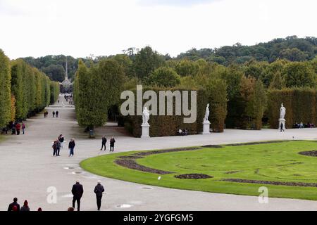 Vienne, Autriche - 6 octobre 2024 : jardins du palais de Schönbrunn avec des visiteurs se promenant parmi des sculptures, des haies bien entretenues et des avenues bordées d'arbres sur un Cl Banque D'Images