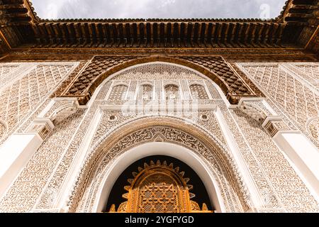 La façade décorative de la porte en arc dans la cour de la madrasa Ben youssef, sculpture en plâtre de stuc ornée, exemple de conception traditionnelle de l'architecture islamique dans Banque D'Images