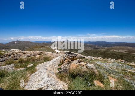 Des vues à couper le souffle depuis le sommet du mont Kosciuszko par temps clair, mettant en valeur de vastes paysages alpins et un terrain accidenté, Australie Banque D'Images