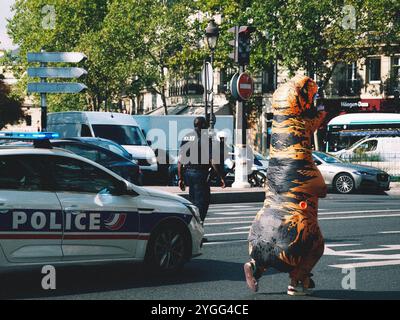 Une manifestation à Paris avec une présence policière et un manifestant en costume T-Rex, mêlant humour et activisme dans une déclaration politique unique. Banque D'Images