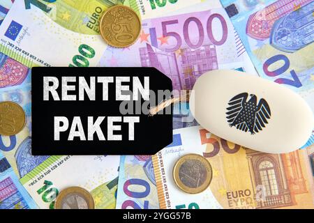 Bavière, Allemagne - 7 novembre 2024 : RENTENPAKET est écrit sur un panneau à côté de l'aigle fédéral et des billets de banque. Image symbolique du paquet de pensions 2, réforme des feux de signalisation des pensions de vieillesse en Allemagne pour les retraités et les seniors allemands. PHOTOMONTAGE *** RENTENPAKET steht auf einem Schild neben Bundesadler und Geld-Scheinen. Symbolbild zum Rentenpaket 2, Ampel-Reform der Altersrente in Deutschland für deutsche Rentner und Senioren. FOTOMONTAGE Banque D'Images