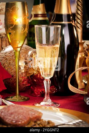 Un verre de champagne sur une table de dîner de Noël décoré. Banque D'Images