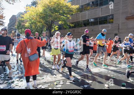 À la barre des 10 miles du marathon de New York 2024, les bénévoles gardent les coureurs hydratés avec des tasses d'eau. Sur Bedford Avenue à Williamsburg, Brooklyn, N. Banque D'Images