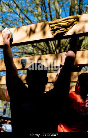 les athlètes participant à un parcours d’obstacles ocr surmontant l’un des défis Banque D'Images