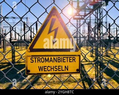 Bavière, Allemagne - 7 novembre 2024 : changer de fournisseur d'électricité, indique un panneau à côté d'une centrale électrique à haute tension pour l'électricité. Image symbolique pour changer de fournisseur d'électricité pour réduire les coûts de l'électricité et comparer les prix de l'électricité. PHOTOMONTAGE *** Stromanbieter wechseln, steht auf einem Schild neben einem Hochspannungswerk für Elektrizität. Symbolbild für den Anbieterwechsel vom Strom um Stromkosten zu reduzieren und den Strompreis zu vergleichen. FOTOMONTAGE Banque D'Images