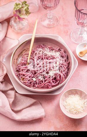 Pâtes roses maison à l'ail, au citron et au parmesan, naturellement colorées par le chou rouge Banque D'Images