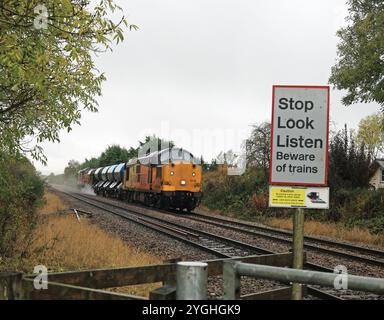 La locomotive Colas no 37116 mène le train de traitement de tête de rail vers la jonction Seamer près de Scarborough sous la pluie samedi le 19.10.2024. Banque D'Images