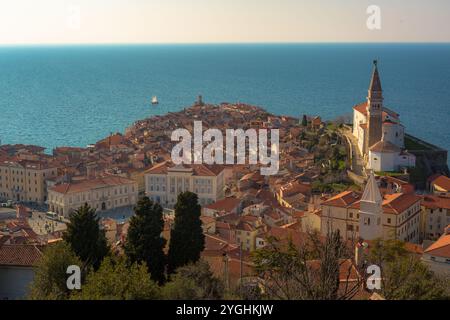 Une vue aérienne de Piran, Slovénie, par une belle journée ensoleillée, mettant en valeur les toits rouges, la tour emblématique de l'église et les eaux bleues époustouflantes de l'ADR Banque D'Images