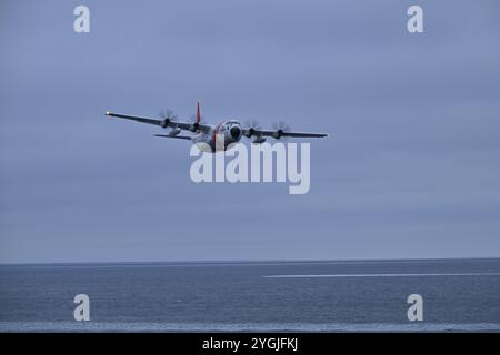 Une station aérienne de la Garde côtière américaine Kodiak HC-130J approche le Cutter de la Garde côtière américaine Healy (WAGB 20) tandis que Healy opère dans la mer des Tchouktches, Oct. 30, 2024. Healy est le seul brise-glace de la Garde côtière spécialement conçu pour soutenir la recherche et il offre une présence américaine à haute latitude et un accès scientifique à des zones trop difficiles à atteindre pour la plupart des navires de recherche. Photo de la Garde côtière américaine par le premier maître Matt Masaschi. Banque D'Images