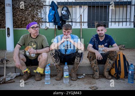 Volontaires se reposant après le nettoyage. Effets des inondations de la DANA du 29 octobre 2024, rue Benetusser, Paiporta, Comunidad de Valencia, Espagne Banque D'Images