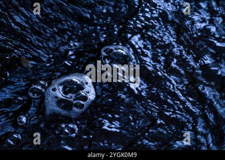 Bulles d'air sur la surface de l'eau d'un ruisseau, heure bleue, Allemagne Banque D'Images