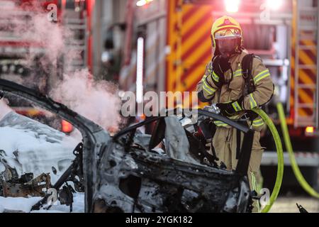 (241107) - KIRYAT Yam, 7 novembre 2024 (Xinhua) - Un membre des forces de sauvetage israéliennes travaille à éteindre un incendie sur le site d'une attaque à la roquette depuis le Liban, à Kiryat Yam, près de Haïfa dans le nord d'Israël, le 7 novembre 2024. (JINI via Xinhua) Banque D'Images